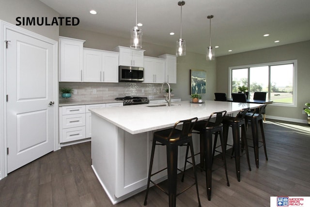 kitchen featuring black stove, dark hardwood / wood-style floors, white cabinetry, hanging light fixtures, and a large island