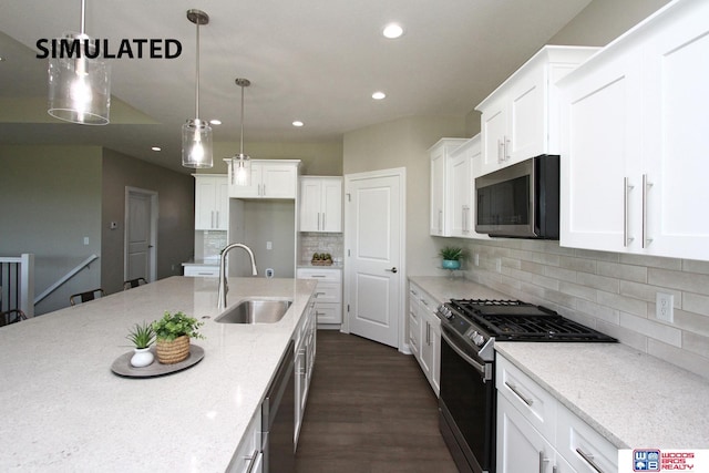 kitchen with pendant lighting, sink, light stone countertops, and stainless steel appliances