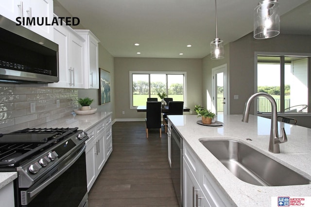 kitchen featuring light stone countertops, stainless steel appliances, sink, dark hardwood / wood-style floors, and white cabinetry