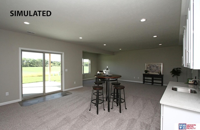 carpeted dining area with sink