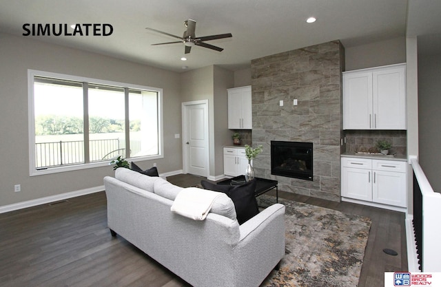 living room featuring dark hardwood / wood-style floors, ceiling fan, and a tiled fireplace