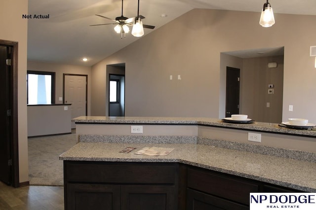 kitchen featuring light hardwood / wood-style flooring, light stone counters, ceiling fan, and lofted ceiling