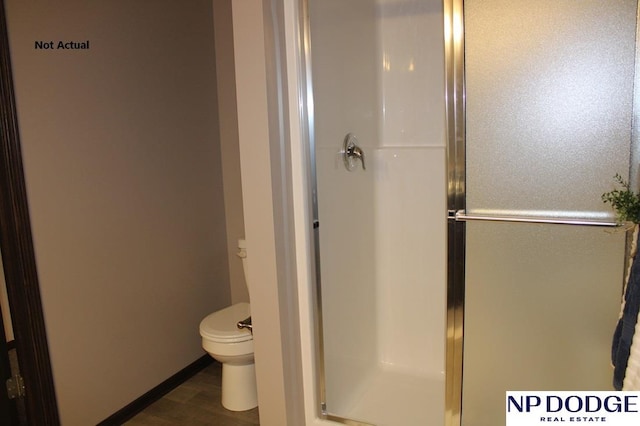 bathroom featuring wood-type flooring, an enclosed shower, and toilet