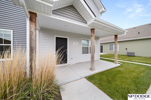 doorway to property with central air condition unit and a yard