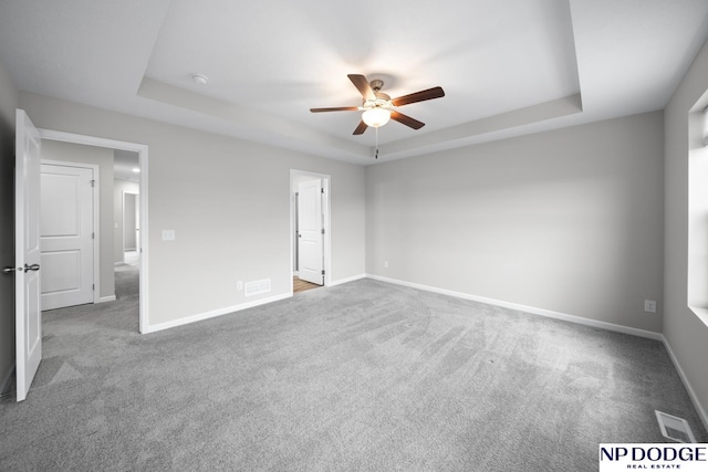 interior space featuring carpet flooring, a raised ceiling, and ceiling fan