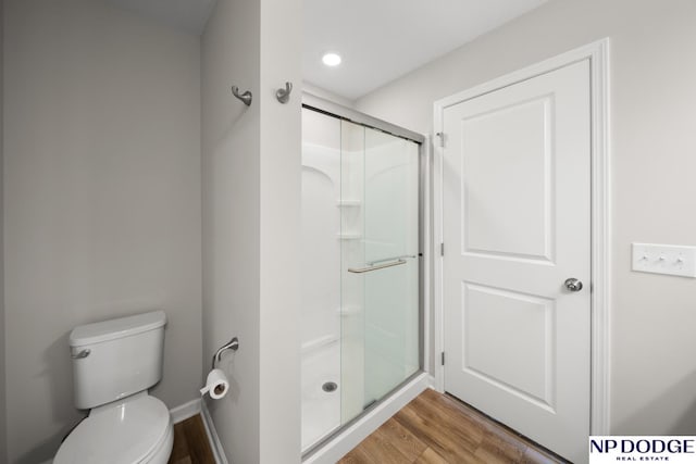 bathroom featuring wood-type flooring, toilet, and walk in shower