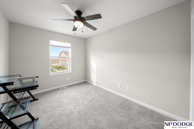 unfurnished office featuring ceiling fan and carpet