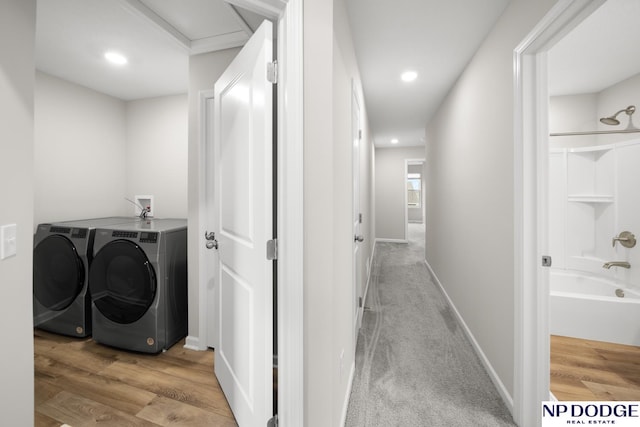 laundry room featuring washing machine and dryer and light wood-type flooring