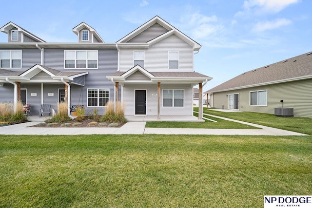 view of front of house with central AC unit and a front yard