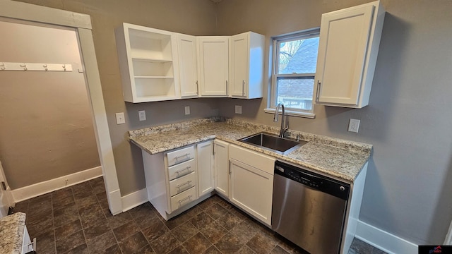 kitchen featuring light stone countertops, white cabinetry, sink, and stainless steel dishwasher