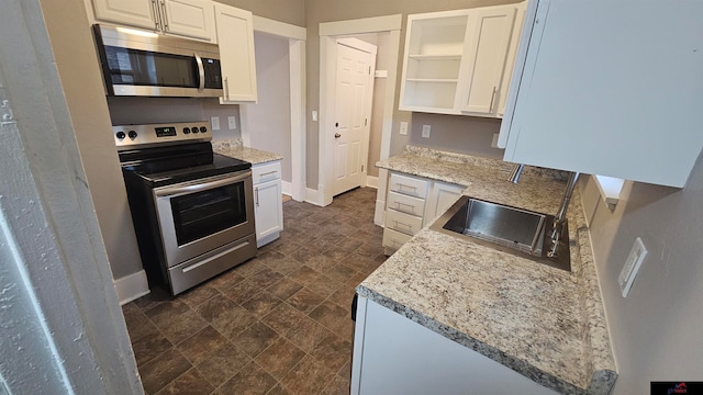 kitchen featuring light stone countertops, white cabinetry, sink, and stainless steel appliances