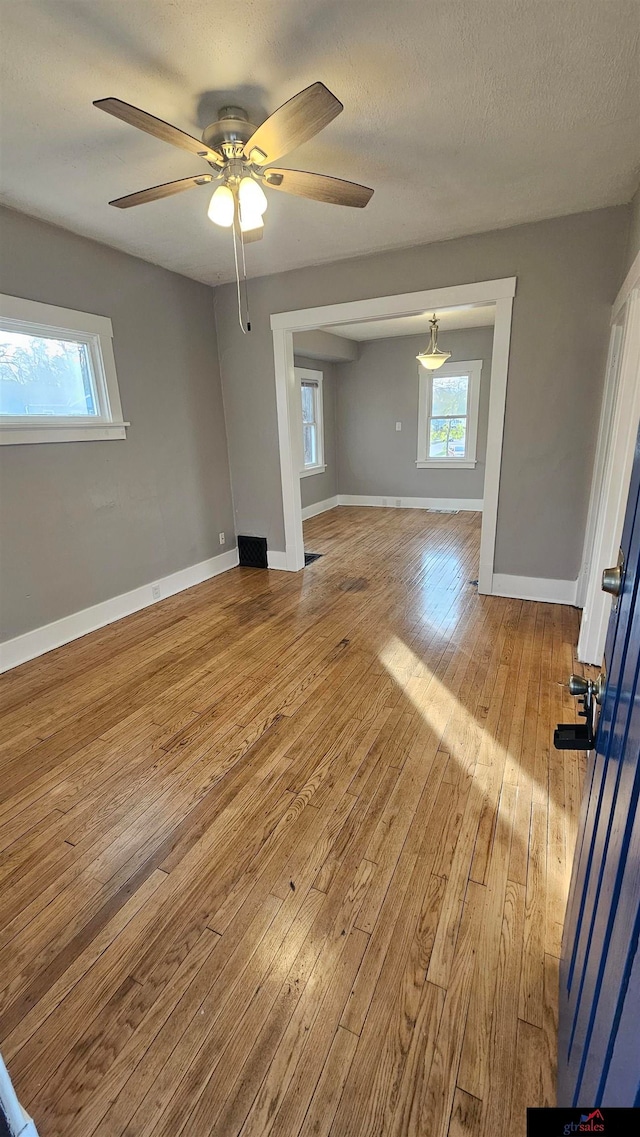 spare room with ceiling fan, a textured ceiling, and light hardwood / wood-style flooring