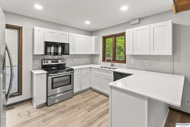 2729 N 129th Cir, Omaha, NE 68164 - kitchen with black appliances, a sink, a peninsula, light countertops, and light wood-style floors
