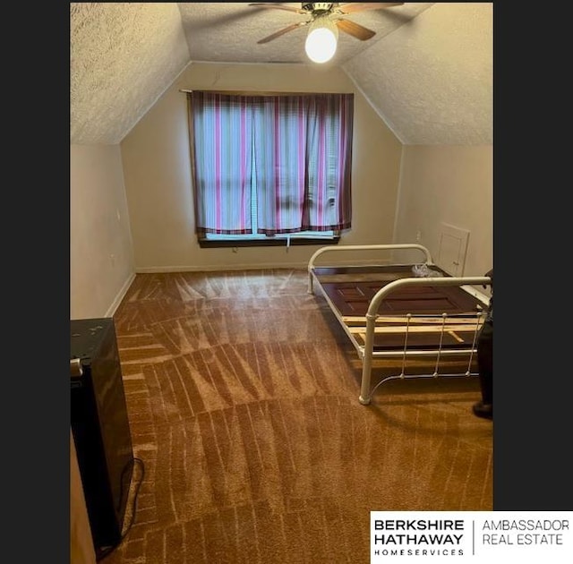 bedroom with carpet, ceiling fan, a textured ceiling, and vaulted ceiling