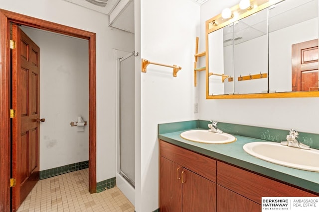 bathroom featuring tile patterned flooring, vanity, and a shower with shower door