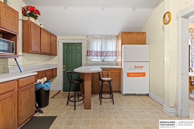 kitchen featuring a kitchen bar and white fridge