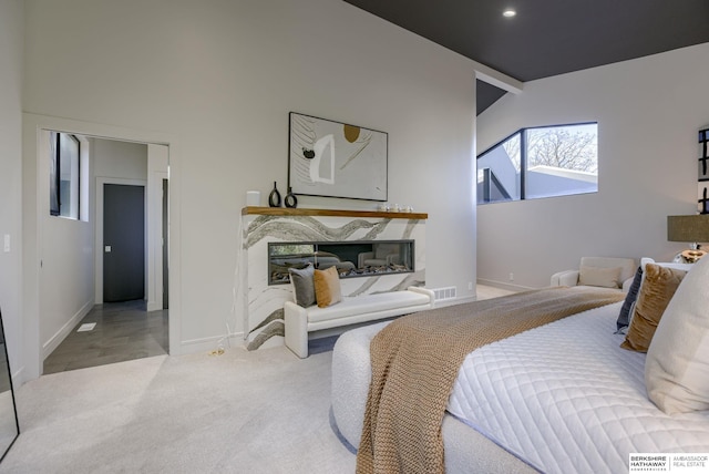 carpeted bedroom featuring a fireplace and vaulted ceiling