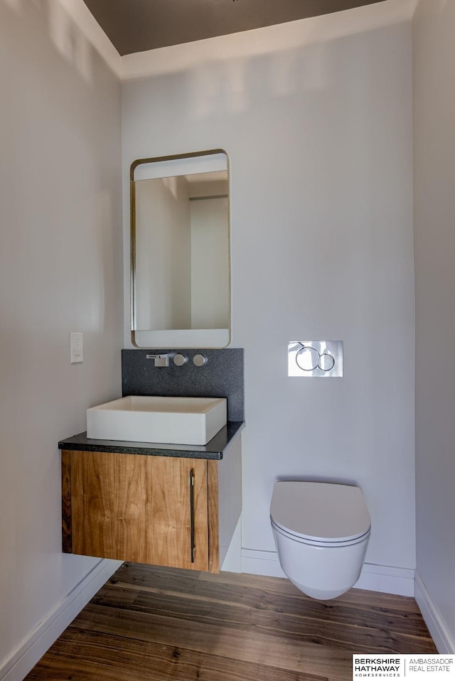 bathroom with toilet, vanity, and hardwood / wood-style flooring