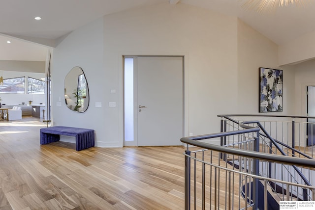 hallway with beam ceiling, light hardwood / wood-style flooring, and high vaulted ceiling