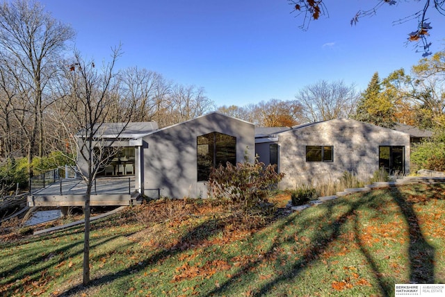 view of side of property with a lawn and a wooden deck