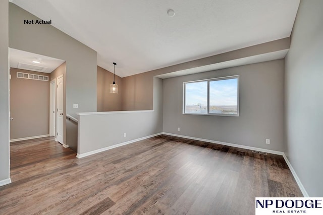 unfurnished room with dark wood-type flooring and vaulted ceiling