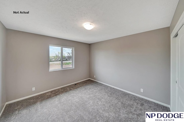 carpeted empty room with a textured ceiling