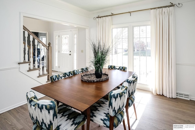 dining room with wood-type flooring and crown molding