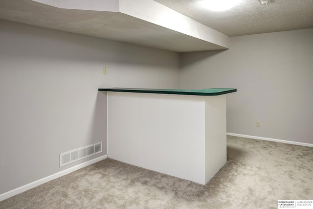 empty room with a textured ceiling and light carpet