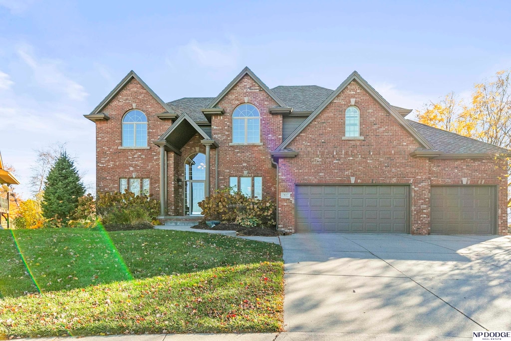 view of property featuring a garage and a front yard