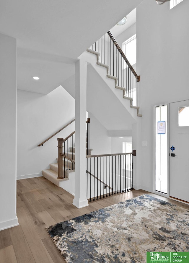 foyer featuring a towering ceiling and light hardwood / wood-style flooring