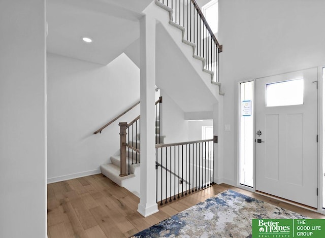 entryway with a towering ceiling and light hardwood / wood-style floors