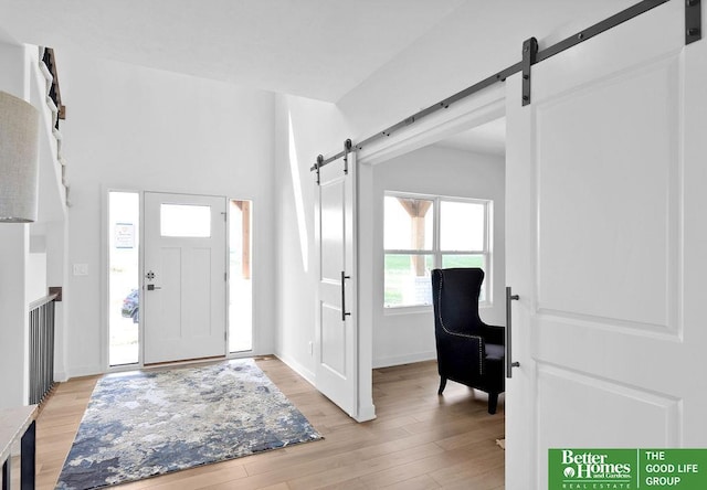 11018 N 161st St, Bennington, NE 68007 - foyer featuring a barn door, light wood-style flooring, and baseboards