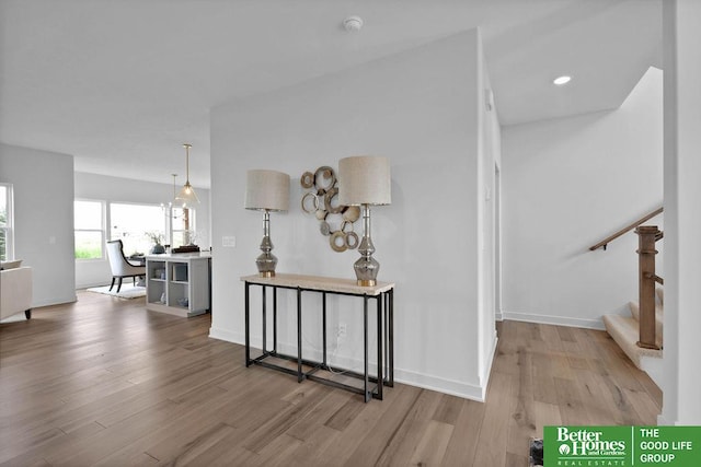 hall with a chandelier and light hardwood / wood-style floors