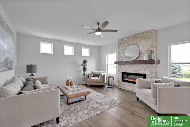 living room with ceiling fan, a fireplace, and light hardwood / wood-style flooring