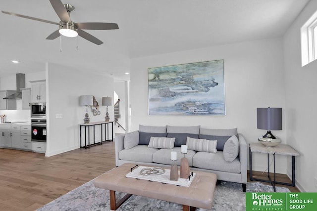 living room featuring ceiling fan and light hardwood / wood-style flooring