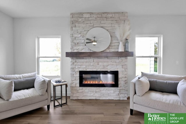 living room with ceiling fan, a fireplace, and wood-type flooring