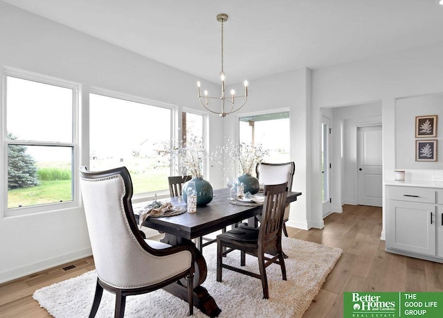 dining space with a chandelier, light hardwood / wood-style floors, and a wealth of natural light