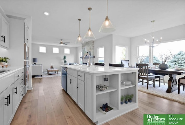 kitchen featuring white cabinets, light hardwood / wood-style floors, a kitchen island with sink, and sink