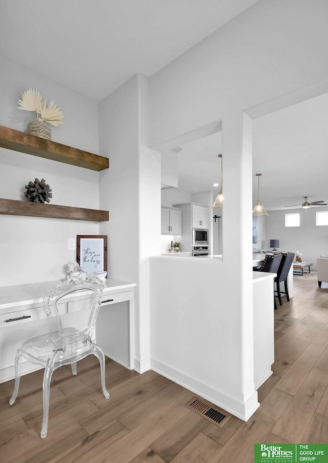 interior space with ceiling fan and wood-type flooring