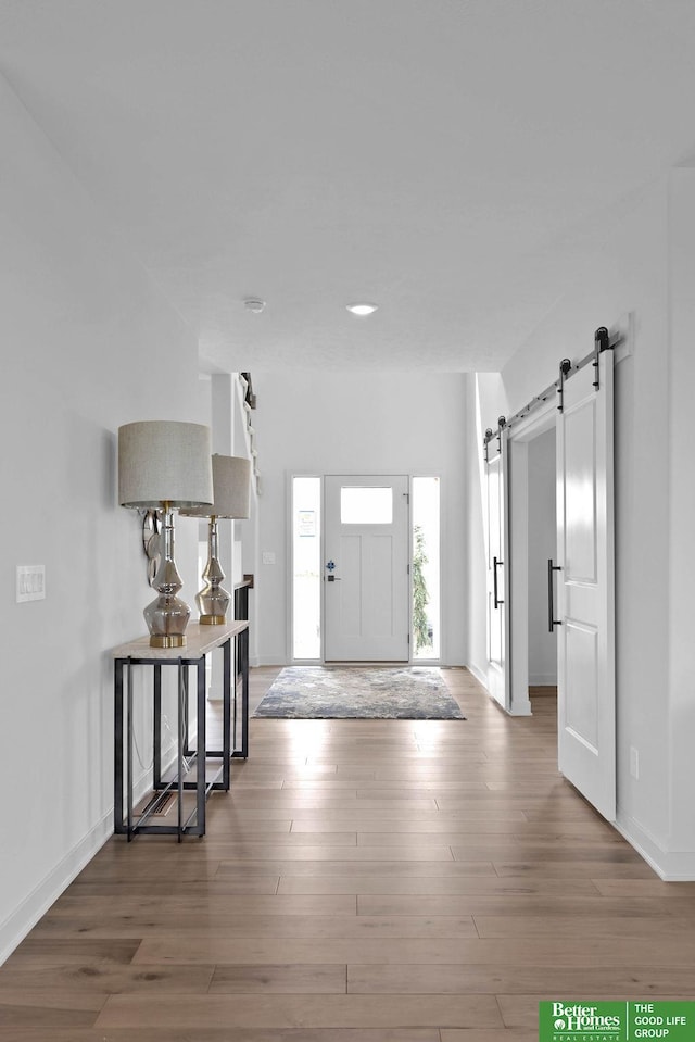 foyer entrance featuring a barn door and dark hardwood / wood-style floors