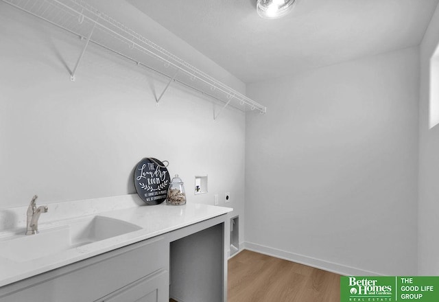 laundry area with washer hookup, electric dryer hookup, sink, and light hardwood / wood-style flooring