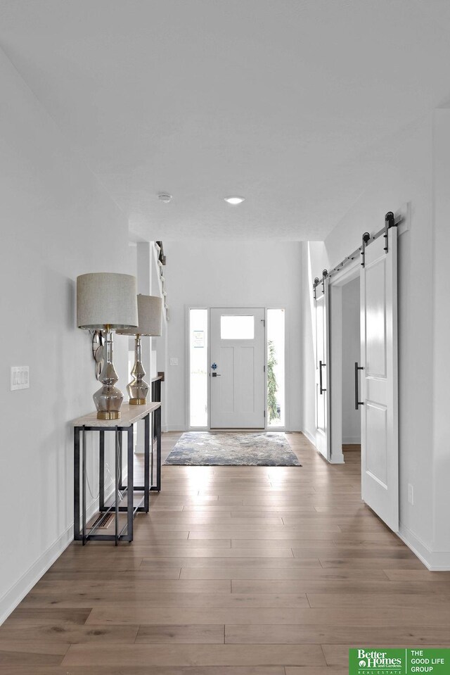 11018 N 161st St, Bennington, NE 68007 - entrance foyer with a barn door, wood finished floors, and baseboards