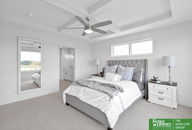 carpeted bedroom featuring a raised ceiling, ensuite bath, ceiling fan, and multiple windows