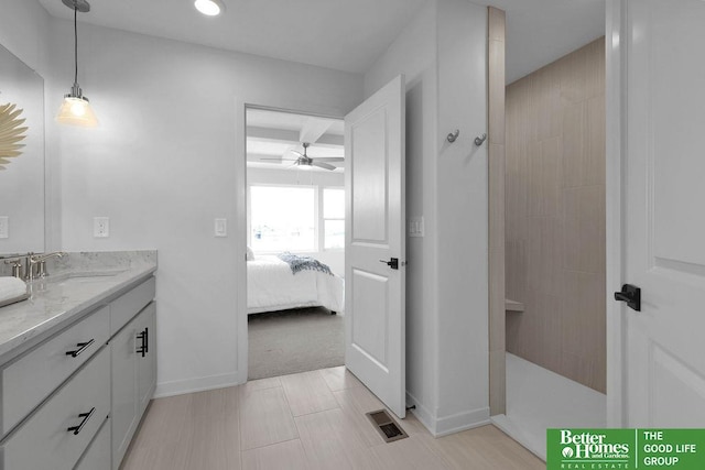 bathroom featuring a tile shower, vanity, and ceiling fan