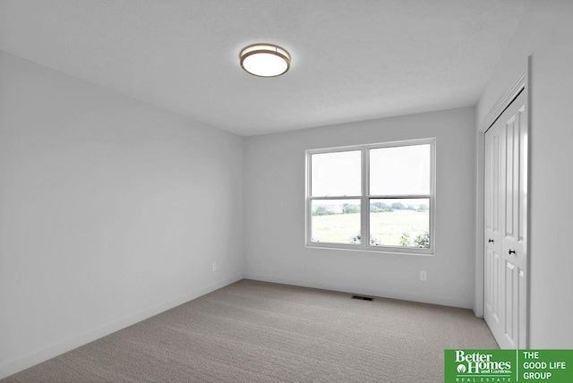 spare room featuring light colored carpet