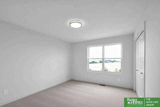 unfurnished room featuring light colored carpet