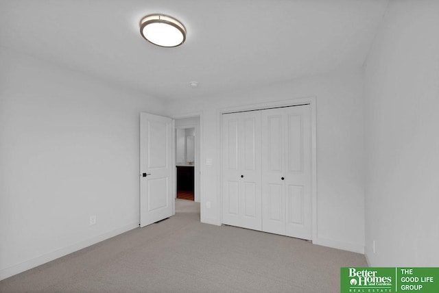 unfurnished bedroom with light carpet and a closet