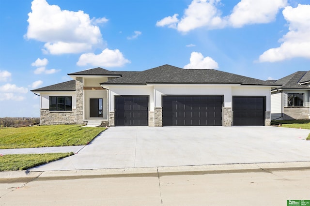 prairie-style home with a garage and a front lawn