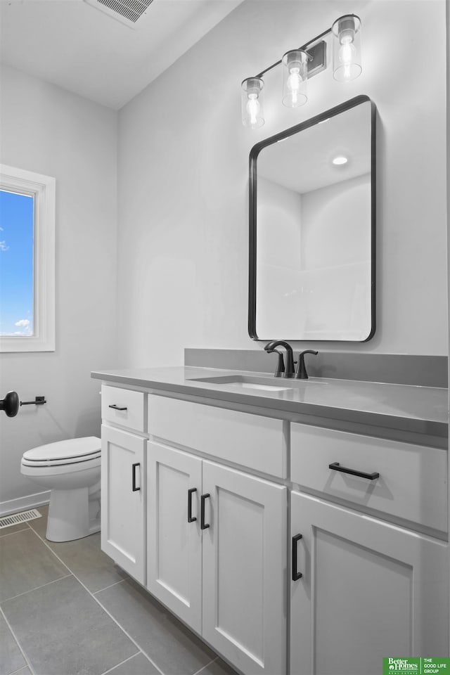 bathroom with tile patterned flooring, vanity, and toilet