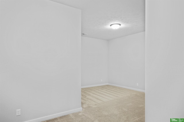 carpeted empty room with a textured ceiling